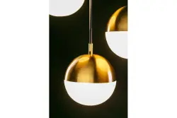 Decorațiunea Abies este un candelabru modern cu sârmă de cupru aurită și o abajur rotund din metal.