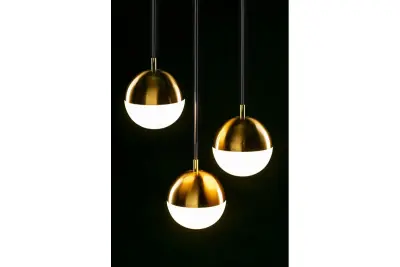 Decorațiunea Abies este un candelabru modern cu sârmă de cupru aurită și o abajur rotund din metal.